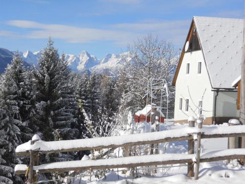 a house in the snow with mountains in the background at Familienbauernhof Imitz, Ferienwohnung in Spital am Pyhrn