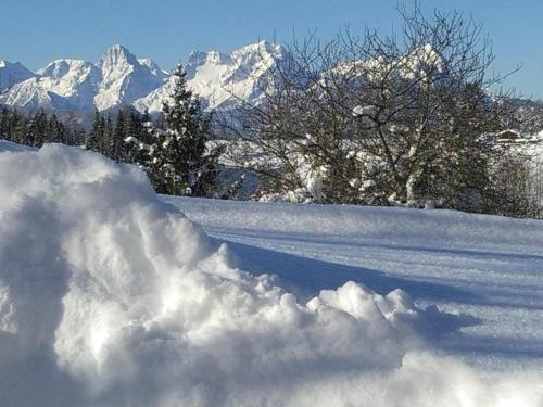 a pile of snow in front of a snow covered mountain at Familienbauernhof Imitz, Ferienwohnung in Spital am Pyhrn