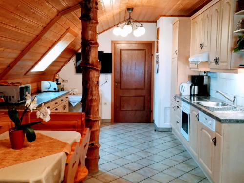 a kitchen with wooden ceilings and a wooden door at Familienbauernhof Imitz, Ferienwohnung in Spital am Pyhrn
