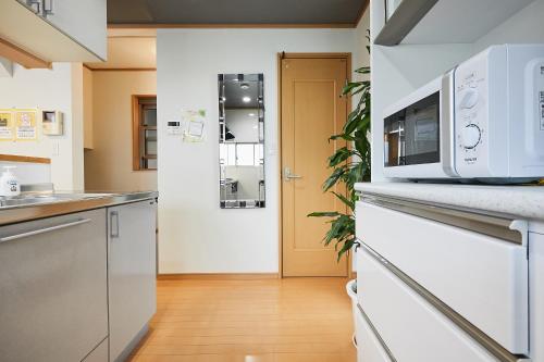 a kitchen with white appliances and a wooden floor at G48-Superior Room in Shinjuku, Tokyo in Tokyo