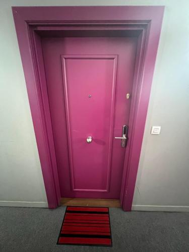 a purple door with a red rug in front of it at 2 PIECES proche du centre PARIS 15 min in Rosny-sous-Bois