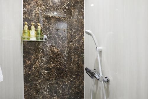 a bathroom with a shower with bottles on a wall at G48-Superior Room in Shinjuku, Tokyo in Tokyo