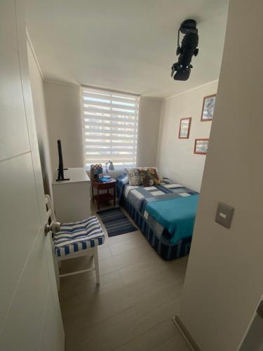Habitación pequeña con cama y ventana en Habitación con baño privado en departamento, en Arica