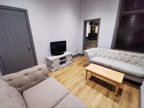 a living room with two couches and a tv at Shared house close to Liverpool city center & LFC/EFC in Liverpool