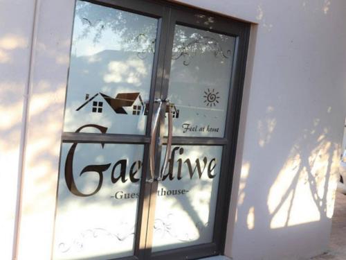 una ventana con un reflejo de una casa en ella en Gaediwe Guesthouse, en Pudumong