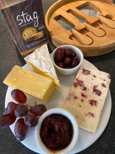 a plate of cheese and grapes and a box of chips at Franklin Mount Boutique Guesthouse in Harrogate