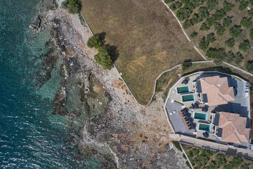 uma vista aérea de uma casa ao lado do oceano em Beachfront Alassa Villas with Private Pools em Kotrónion