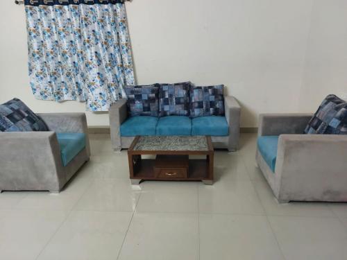 a living room with two couches and a coffee table at Melody 2 Bedroom Apartment in Hyderabad in Hyderabad