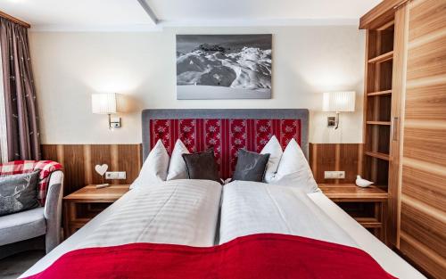 Schlafzimmer mit einem großen Bett mit einem roten Kopfteil in der Unterkunft Appartements Eldorado in Lech am Arlberg