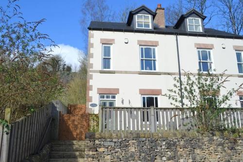 a white house with a fence in front of it at Sleeps 8 Matlock/ Matlock Bath Pet Friendly in Matlock Bank
