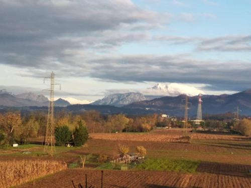 a field with a tower and mountains in the background at 106 gradini in Bottanuco