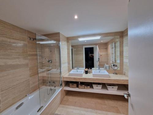 a large bathroom with two sinks and a shower at Superbe appartement avec vue mer in Estepona