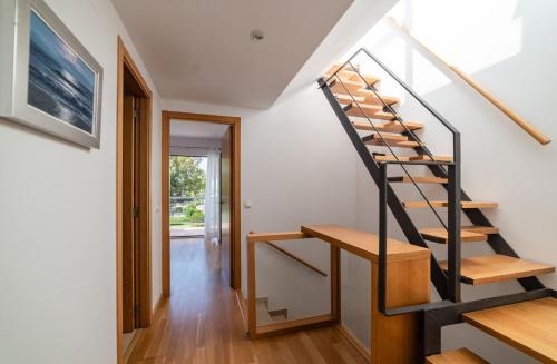 a staircase in a home with white walls and wooden floors at Casa Residencial Playa Fontanilla in Conil de la Frontera