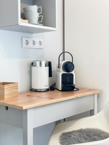 a desk in a kitchen with a coffee maker on it at Landhaus Nordstern Hotel garni in Utersum