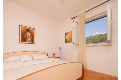a bedroom with a bed and a window at Apartment Milena in Novigrad Dalmatia