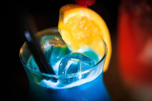 a glass with a blue drink with an orange slice at Кімнати в центрі з усіма зручностями та окремим входом in Ivano-Frankivsʼk