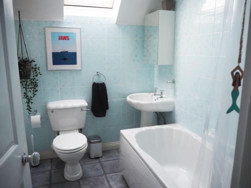 a bathroom with a toilet and a sink at A Pebbles Throw - 300m from the beach. in Westward Ho
