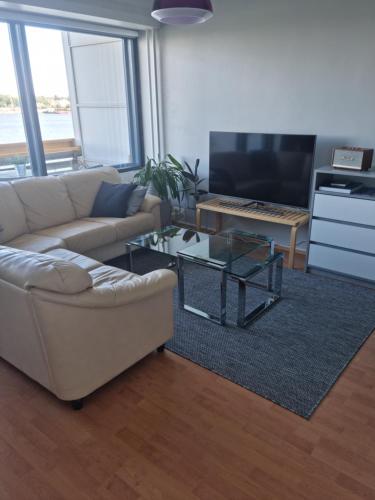 a living room with a couch and a table at Studio with balcony and a great sea view in Helsinki
