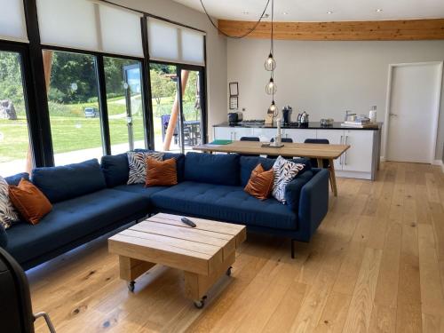 a living room with a blue couch and a table at Yorkshire Dales Lodge 2 by Together Travel - 3-Bed Family Retreat in Richmond
