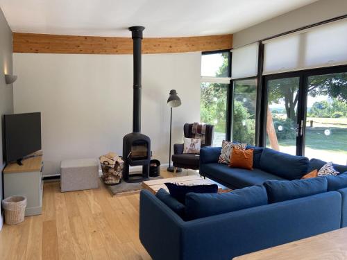 a living room with a blue couch and a fireplace at Yorkshire Dales Lodge 2 by Together Travel - 3-Bed Family Retreat in Richmond