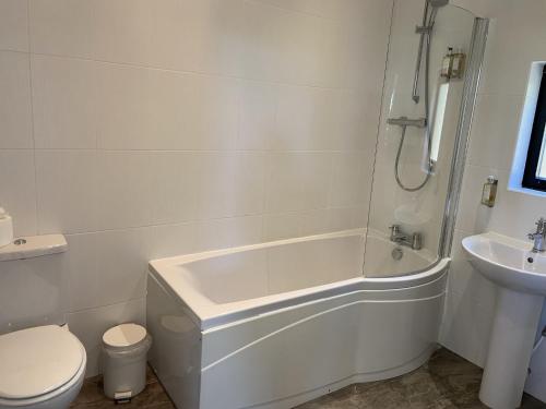a bathroom with a tub and a toilet and a sink at Yorkshire Dales Lodge 2 by Together Travel - 3-Bed Family Retreat in Richmond