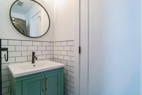 W łazience znajduje się umywalka i lustro. w obiekcie Maison ancestrale complètement rénovée 4 chambres w mieście Bromont