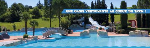 un parc aquatique avec toboggan dans un complexe dans l'établissement Les Jardins d’Oc ٭ Revel ٭ WIFI ٭Jardin ٭T3 Neuf, à Revel