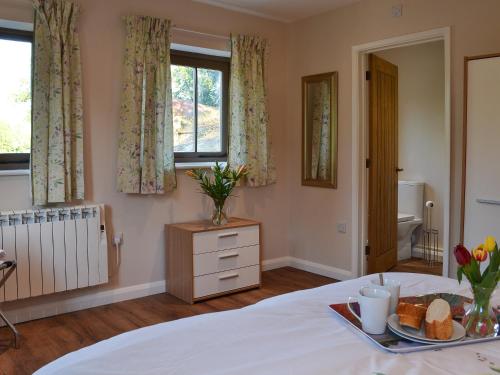 a bedroom with a bed with a tray of bread and a window at The Old Parlour in Sedlescombe