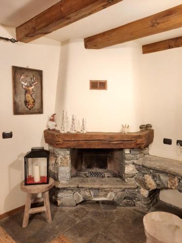 una chimenea de piedra en la sala de estar con una silla en Derby Village, en Villaret