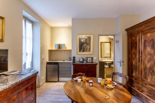 - une cuisine avec une table en bois dans une chambre dans l'établissement La Maison d'Aristide - Les Univers de Panette - Jacques Cœur, à Bourges