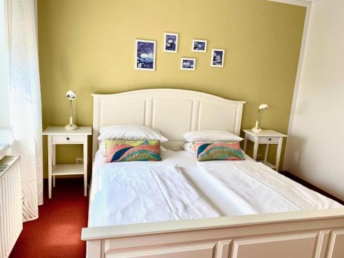 a bedroom with a white bed with two night stands at Ferienapartments Spreewaldwiesen in Vetschau