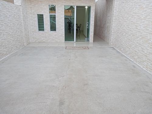 an empty room with a glass door in a building at Casa B de veraneio com estacionamento fechado in Ilha Comprida