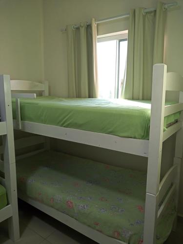 a bedroom with two bunk beds and a window at Casa B de veraneio com estacionamento fechado in Ilha Comprida