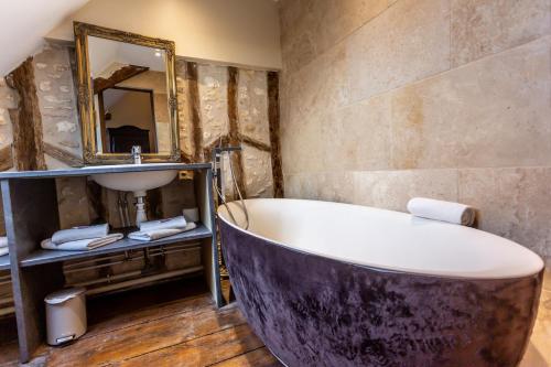 ein Badezimmer mit einer großen Badewanne und einem Waschbecken in der Unterkunft La Maison d'Aristide - Les Univers de Panette in Bourges