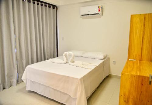 1 dormitorio con 1 cama con toallas en Cond. Fechado, na Ponta do Mutá, en Maraú