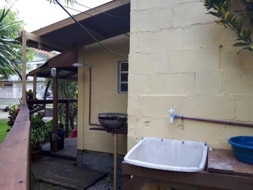 ein weißes Waschbecken an der Seite eines Hauses in der Unterkunft Mini casa (kit net) in Florianópolis