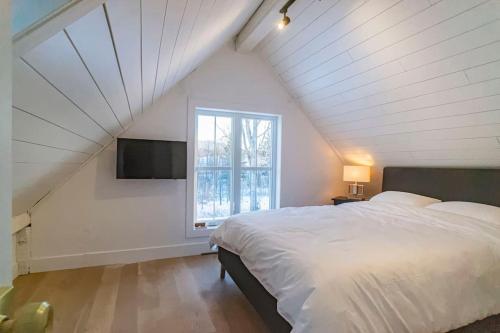 een slaapkamer met een groot bed en een raam bij Maison 3 chambres à coucher vue sur la montagne in Bromont