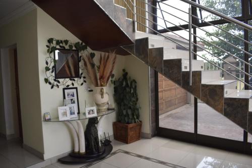 a living room with a staircase and a mirror at Lalela House in Johannesburg