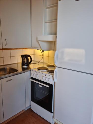 a kitchen with a white stove and a refrigerator at Studio with balcony and a great sea view in Helsinki