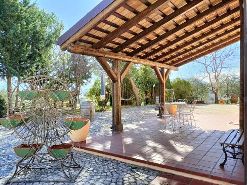 a patio with chairs and a wooden pergola at Aromi di casa in Pianella
