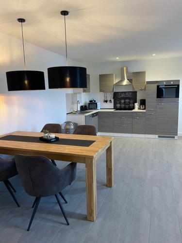 Una cocina con una mesa y sillas de madera. en MR Ferienwohnung - Wohnung Emma, en Schellerten