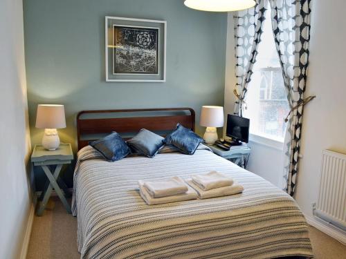 a bedroom with a bed with two towels on it at Corner View in Broadstairs
