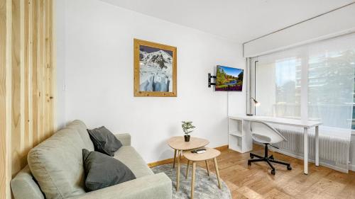 ein Wohnzimmer mit einem Sofa und einem Schreibtisch in der Unterkunft HOMEY HARBOR - Proche Tram - Parking gratuit - Balcon privé - Wifi & Netflix in Ambilly