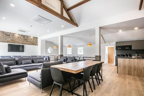 a dining room and living room with a table and chairs at Dovedale Manor in Tissington