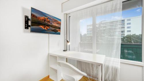 einen weißen Schreibtisch in einem Zimmer mit Fenster in der Unterkunft HOMEY HARBOR - Proche Tram - Parking gratuit - Balcon privé - Wifi & Netflix in Ambilly