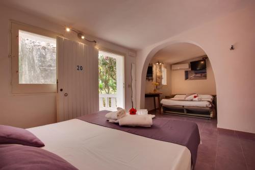 1 dormitorio con 2 camas y ventana en L'Oasi Villaggio Albergo en Favignana