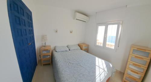 a bedroom with a blue bed and a window at la ventana al mar in Jávea