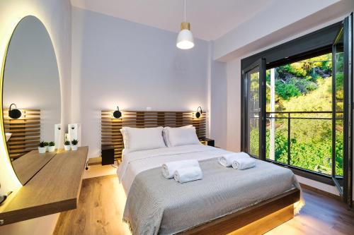 a bedroom with a large bed and a large window at Strefi Hill Suites in Athens