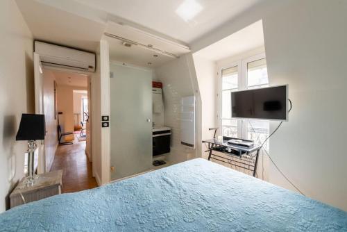 une chambre avec un lit et une télévision à écran plat dans l'établissement Appartement vue Tour Eiffel, à Paris