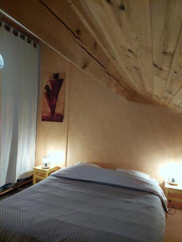 une chambre avec un lit avec un plafond en bois dans l'établissement Gite Les Loges d'Arbez, à Septmoncel